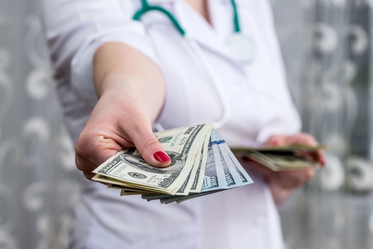 doctor physician hands giving money closeup: © RomanR - stock.adobe.com