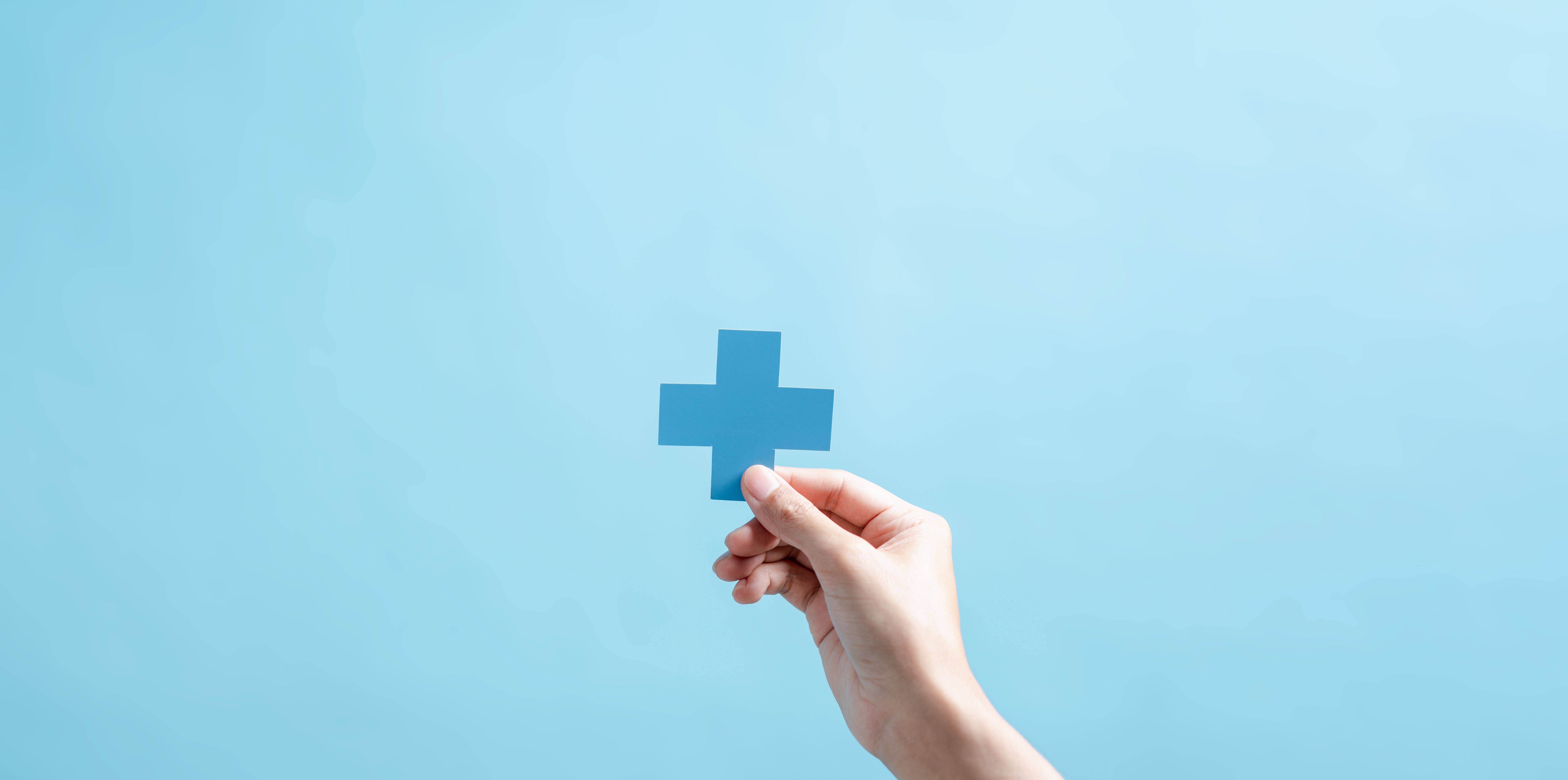 hand holding up medical cross