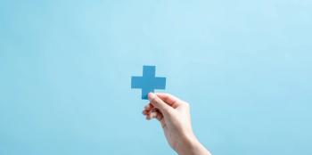 hand holding up medical cross