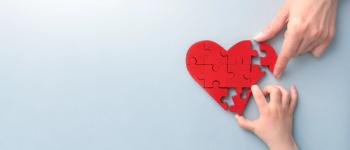 hands putting heart puzzle together
