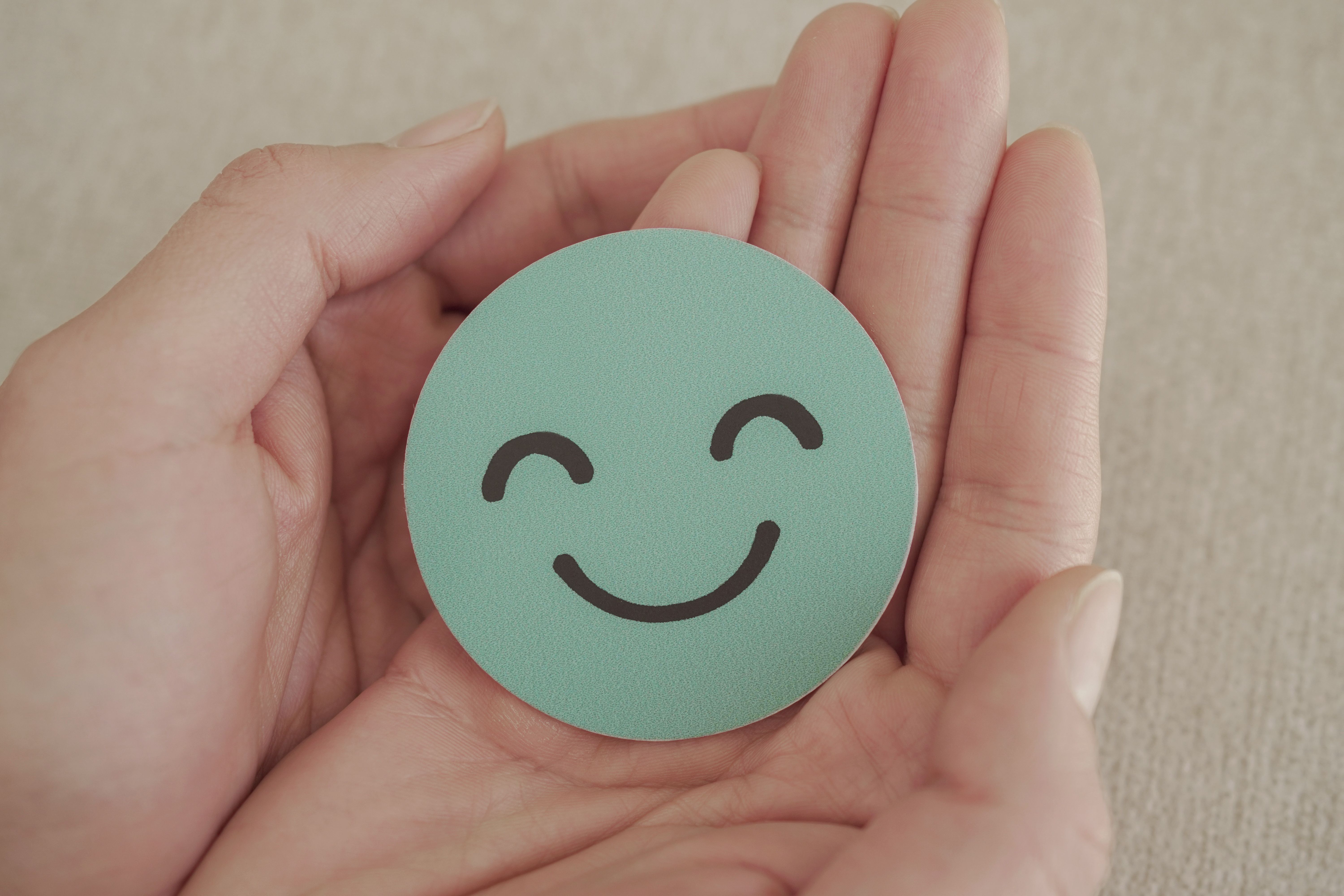 hands holding green happy smile face paper: © SewcreamStudio - stock.adobe.com