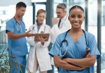 woman doctor with other doctors in background ©peopleimages.com-stock.adobe.com