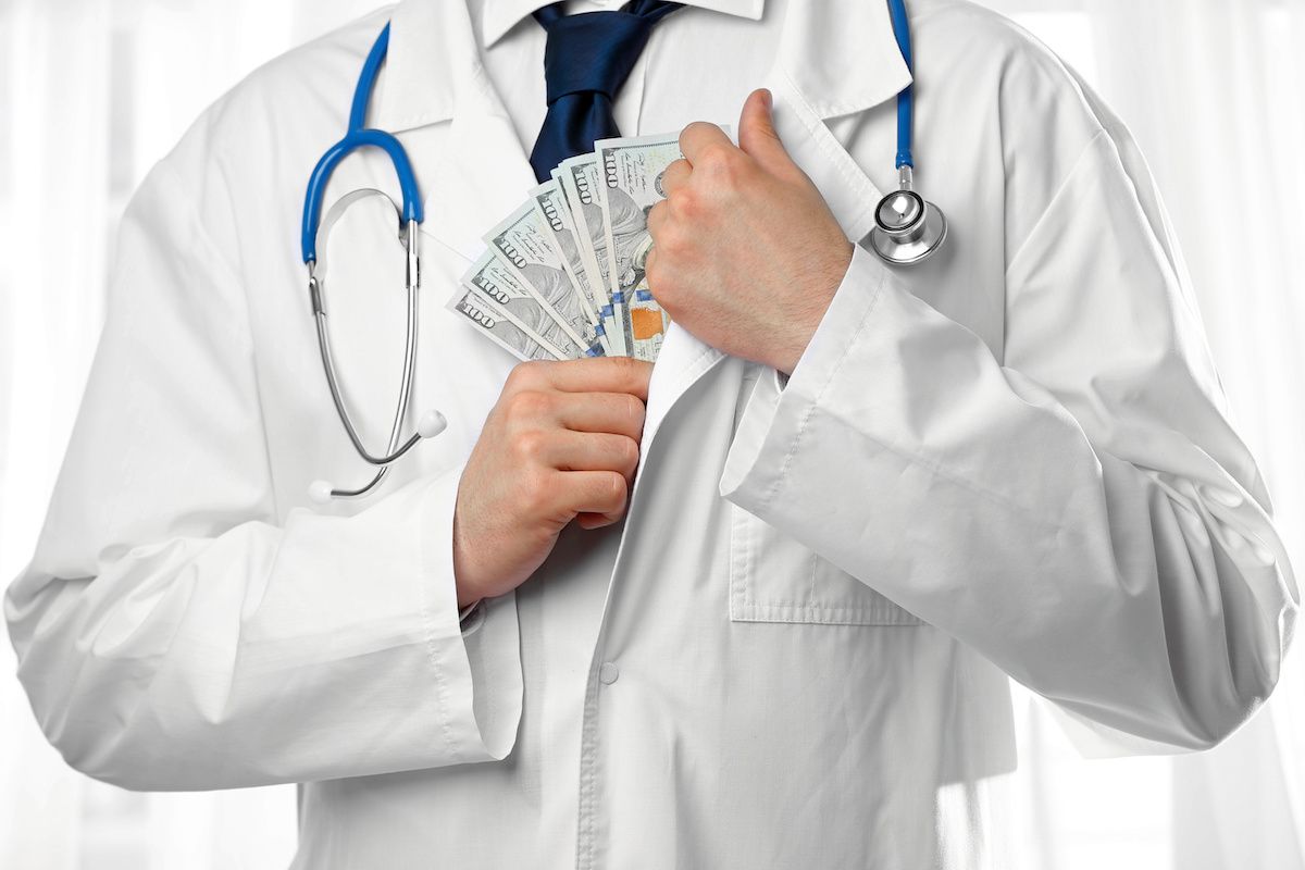 doctor putting money in coat pocket: © Africa Studio - stock.adobe.com