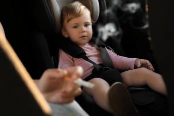 child in car seat with the hand of a person smoking in the foreground | ©New Africa stock.adobe.com