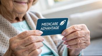 An older woman holding a card that says Medicare Advantage | ©Kannika stock.adobe.com