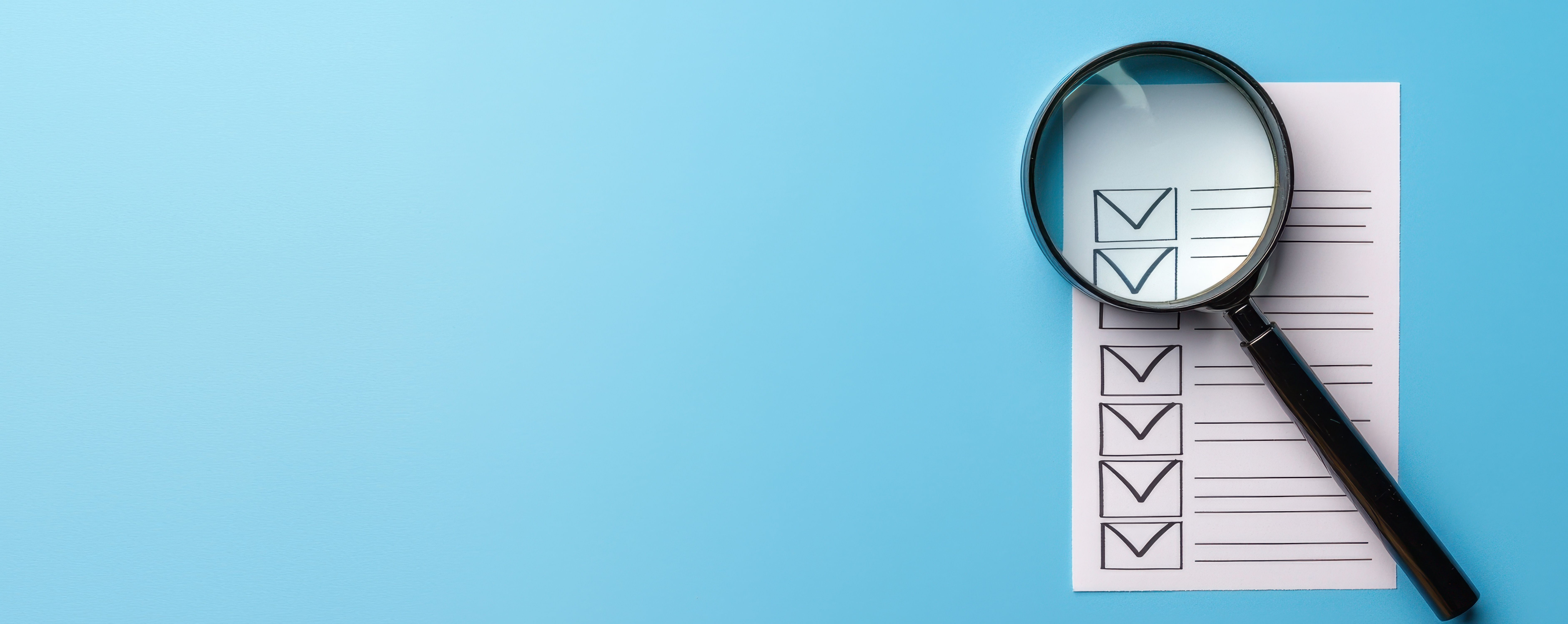 magnifying glass on report with a light blue background | image credit: ©vatcharapong stock.adobe.com