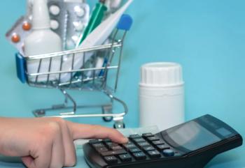 calculator with miniature grocery cart of drugs | Image credit: ©syhin_stats stock.adobe.com