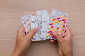 a person holding five blister packs of pills | Image credit: JEROSenneGs stock.adobe.com