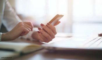 Person using smartphone and computer
