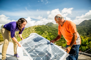 Student helping install solar panels