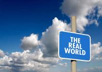 A sign that says real world, blue with white lettering | @Steve Ball stock.adobe.com