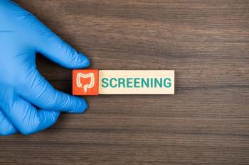 hand in blue glove holding block with image of the colon with screening spelled out next to ti | @Tom stock.adobe.com