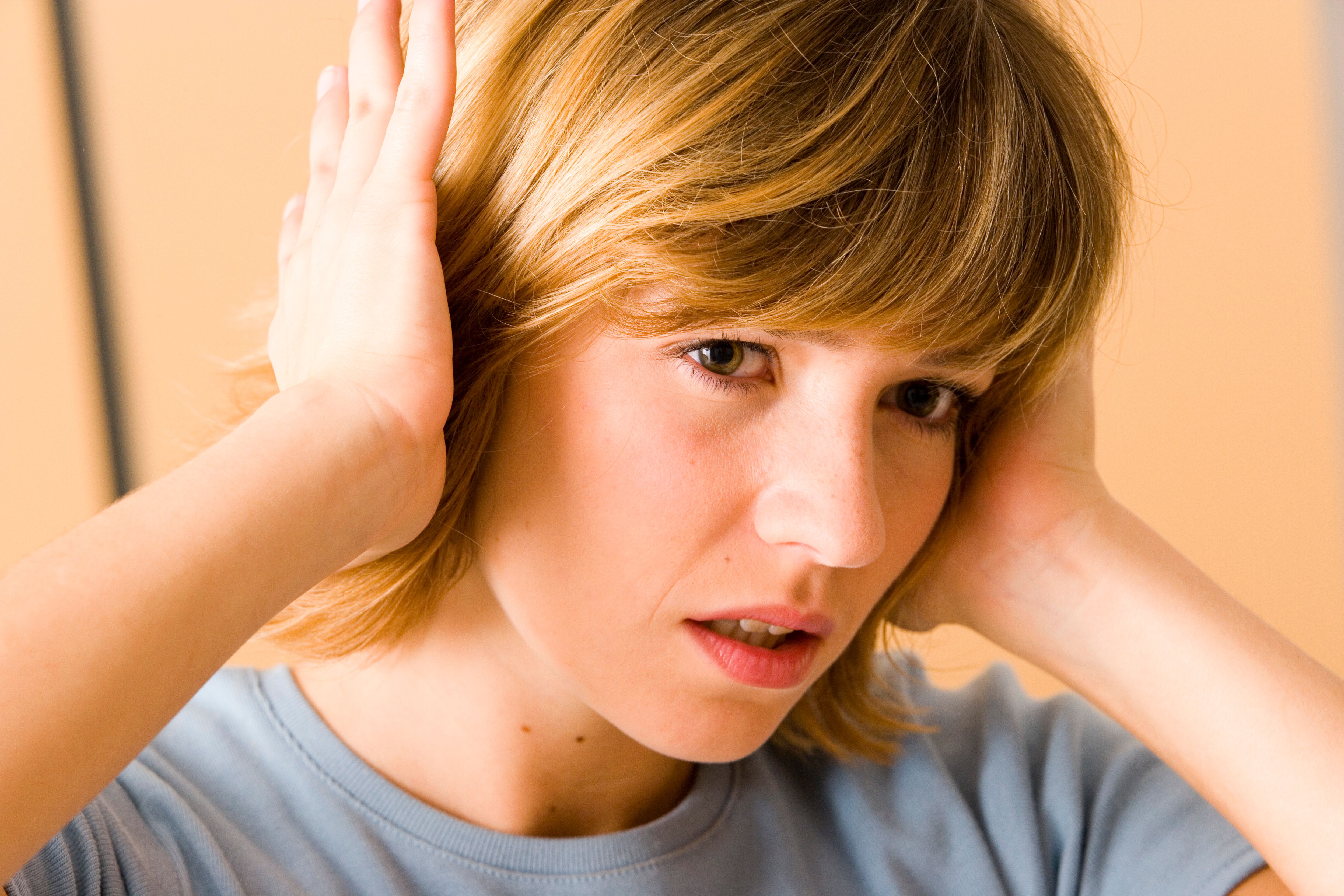 woman holding hands over her ears looking uncomfortable | Image credit: ©RFBSIP stock.adobe.com