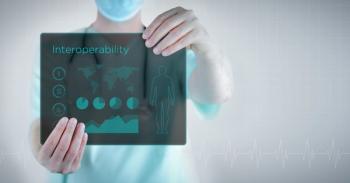 person holding sign that ways interoperability | image credit: @MQ-illustrations stock.adobe.com