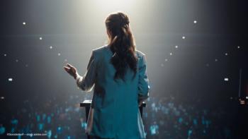A woman stands onstage in front of an audience, delivering a lecture. Concept image for named lectures at Academy of American Ophthalmology (AAO) 2025 meeting. Image credit: ©Gorodenkoff – stock.adobe.com