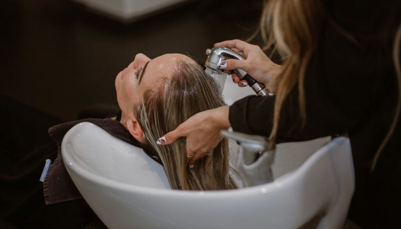 woman getting hair highlights at the salon