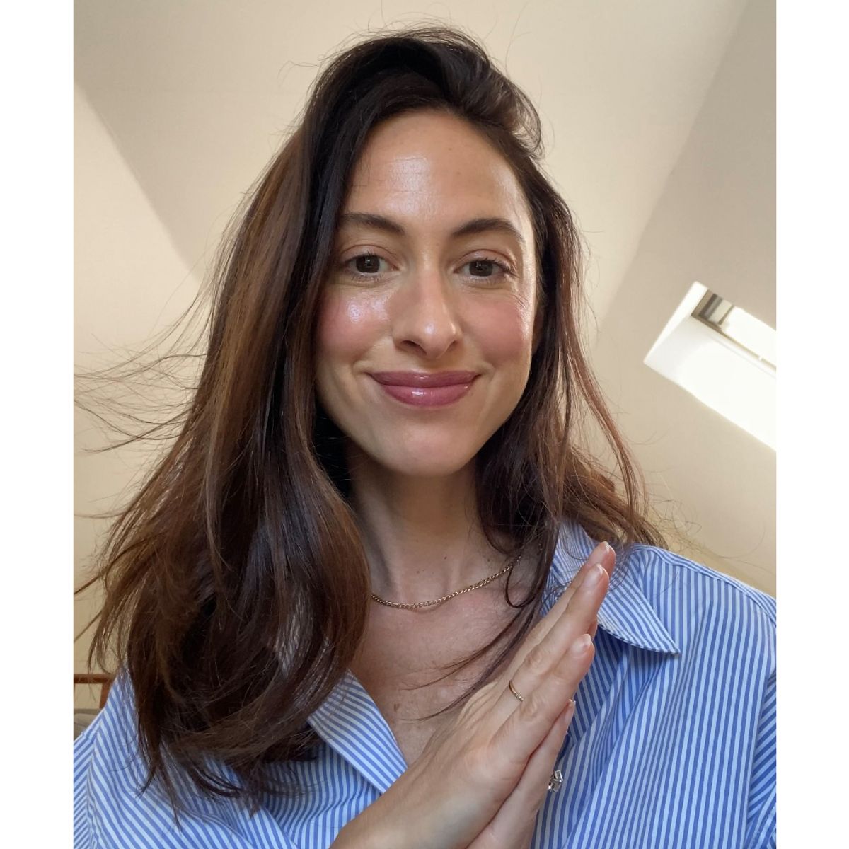 Woman in blue collared shirt with blow-dried hair