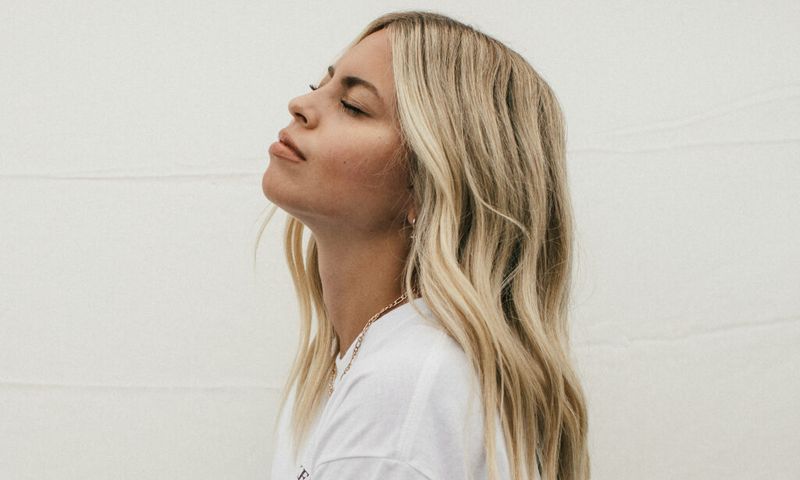 side profile of woman with blonde hair looking up with eyes closed
