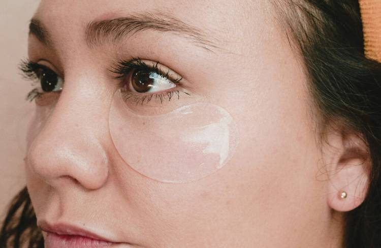 close up of woman wearing an under-eye patch looking to the side