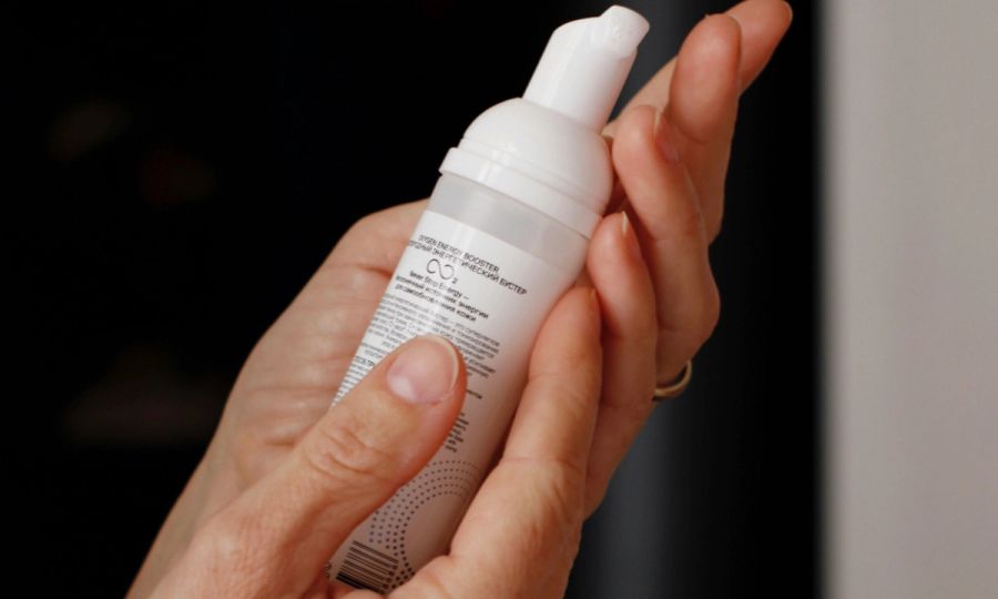 woman reading ingredients labels on skin care bottle