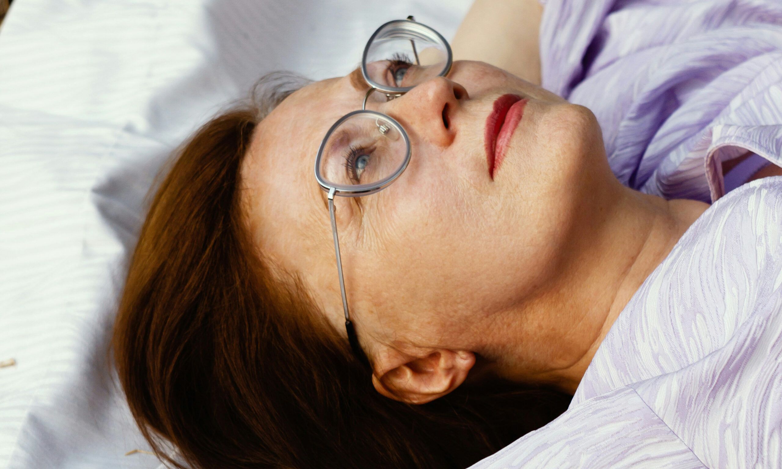 mature woman laying on ground looking up