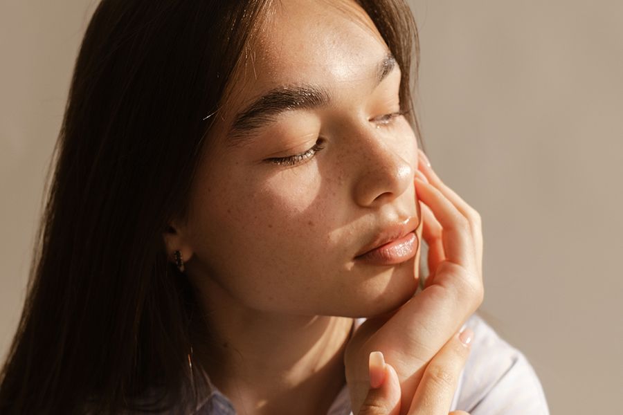 young woman with hand on chin looking to the side