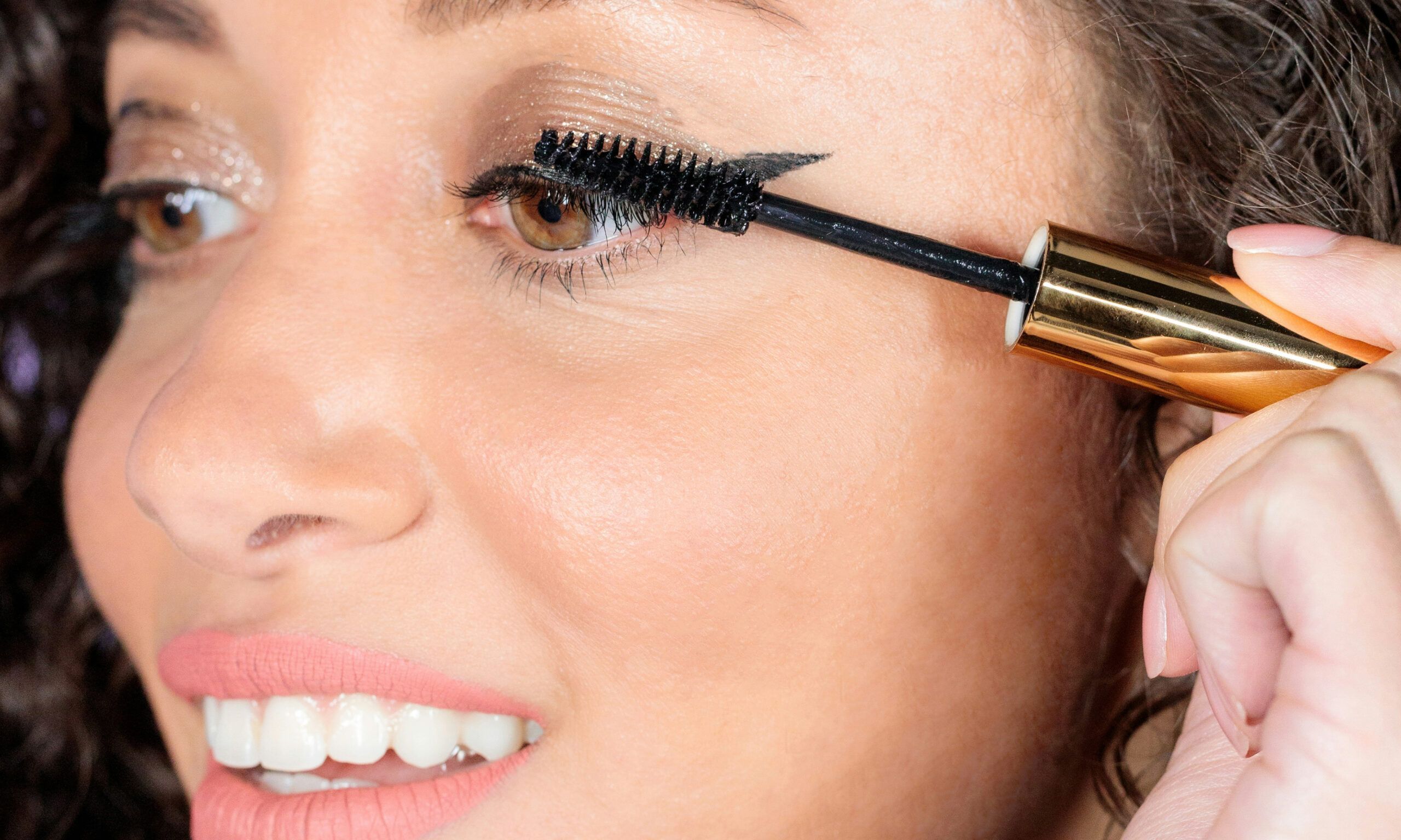 woman applying mascara to eyelashes