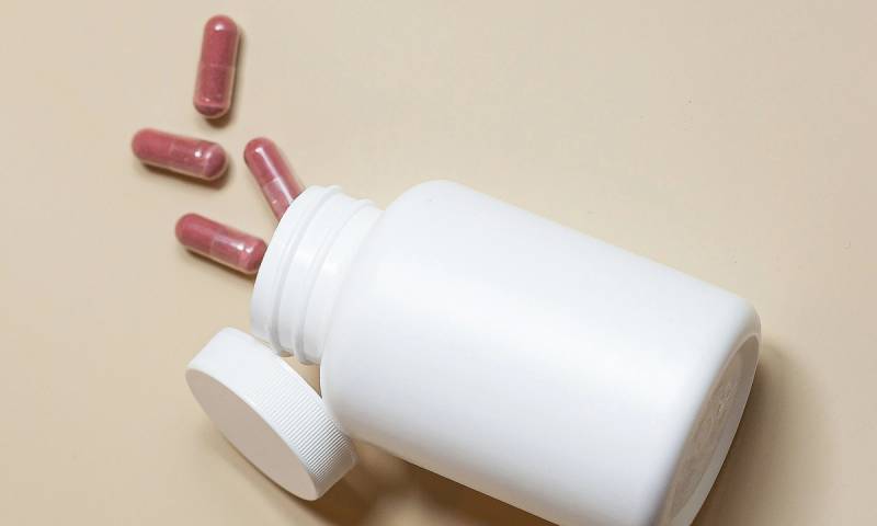 white pill bottle with pills spilling out