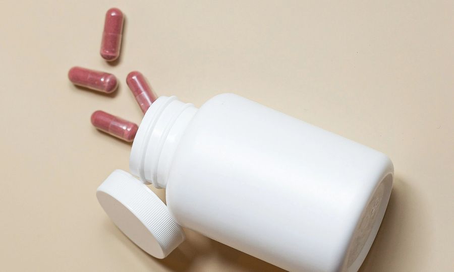 white pill bottle with pills spilling out