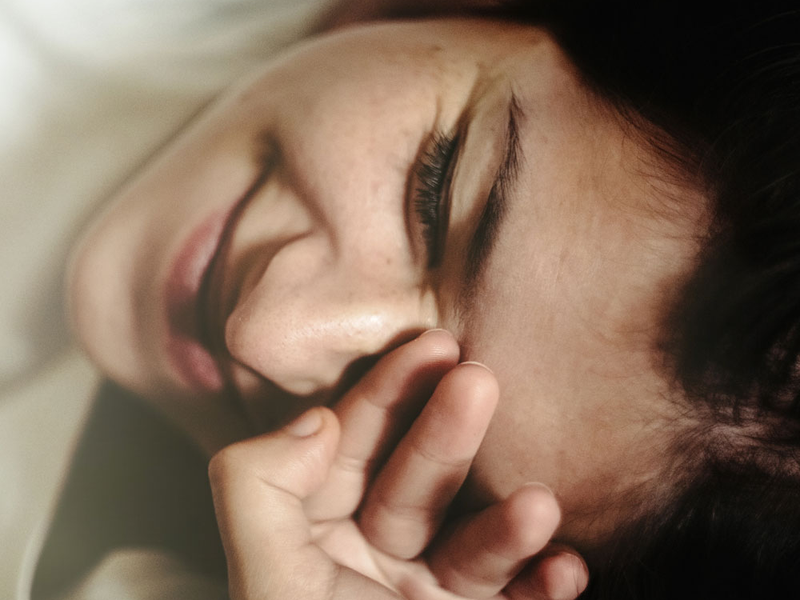 woman scrunching her face with hand over her face