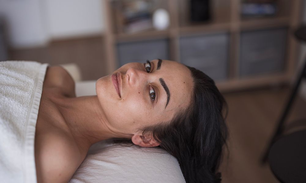 Satisfied young woman resting after a facial massage