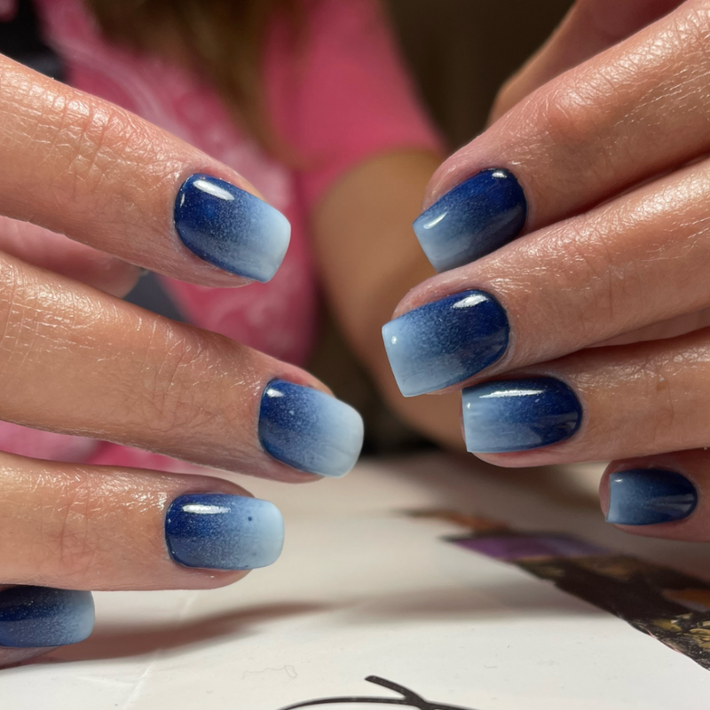 A close up of a woman's hands with a denim nails design