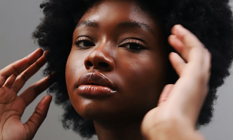 beautiful black woman with hands up near face