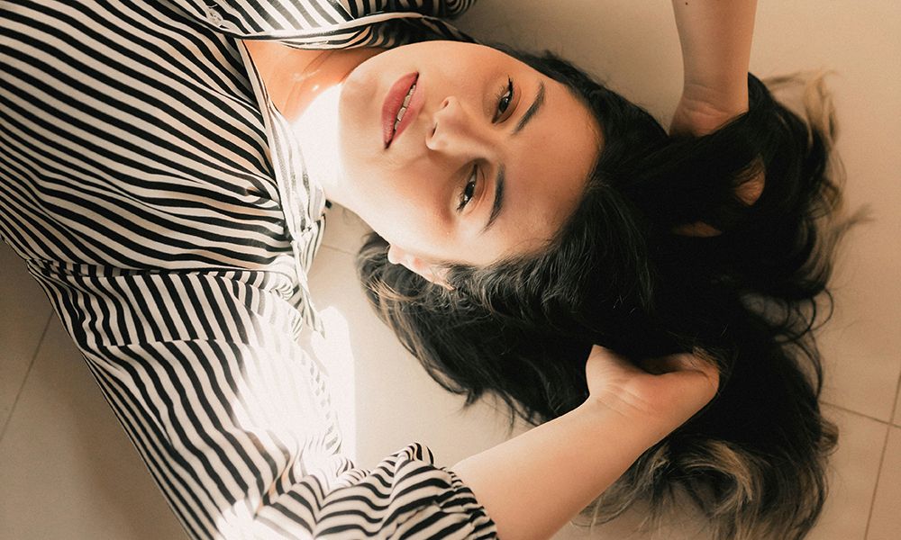 woman lying on floor touching hair