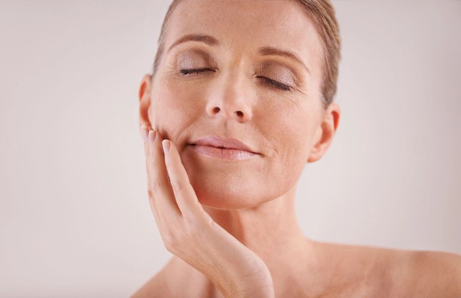 woman with eyes closed touching cheeks