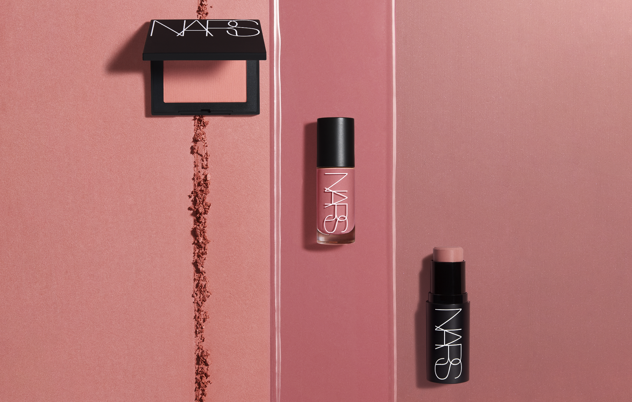 Three NARS blush formulas in a peach-pink shade—a powder compact, a liquid blush bottle and a cream stick—arranged on a rose background with a swipe of loose powder and a streak of liquid product