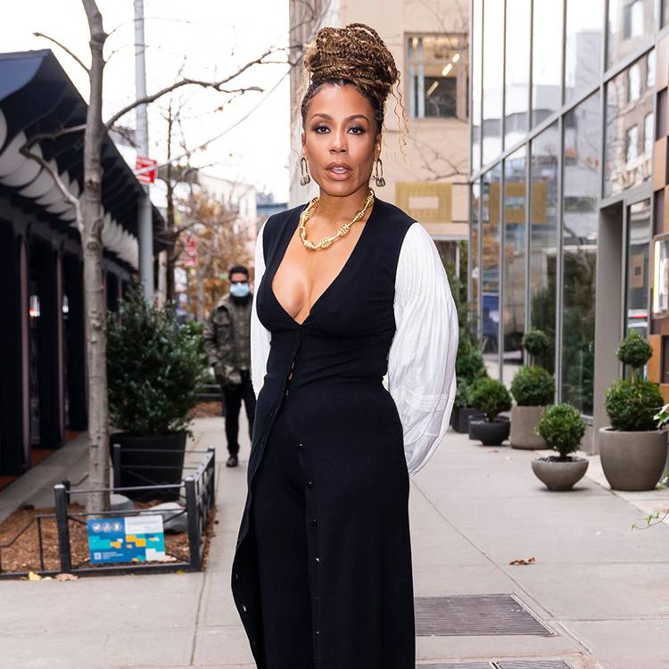 Karen Pittman walking outside in white and black outfit with braided top bun