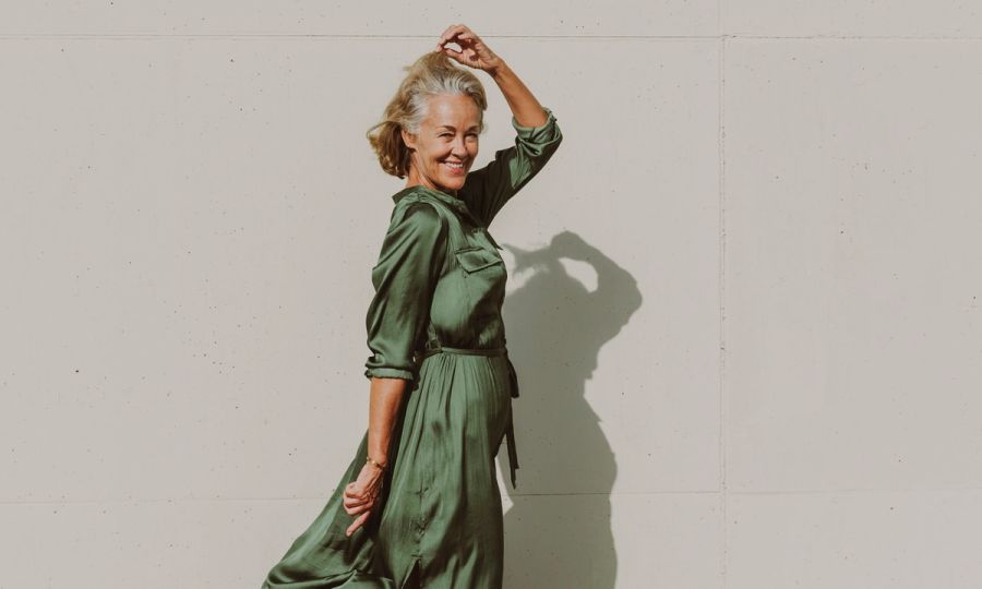 Smiling mature woman dancing on sunny day