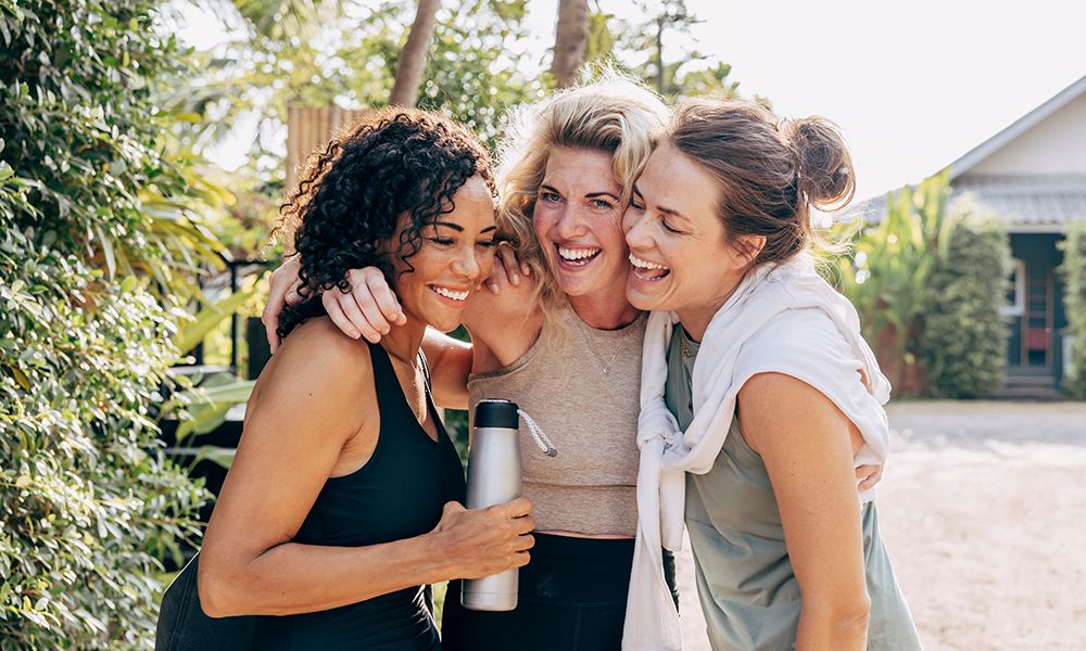 Happy female friends embracing each other at wellness resort