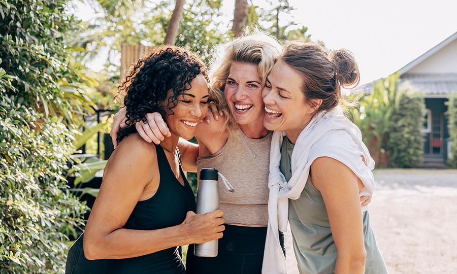 Happy female friends embracing each other at wellness resort