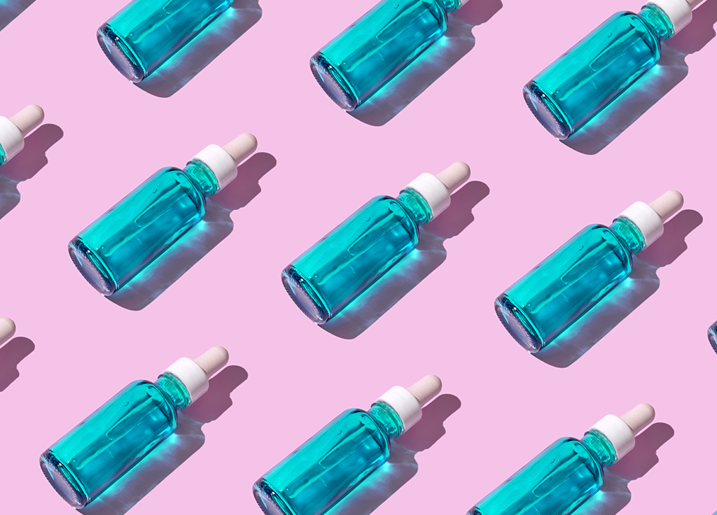 blue serum bottles on light purple background