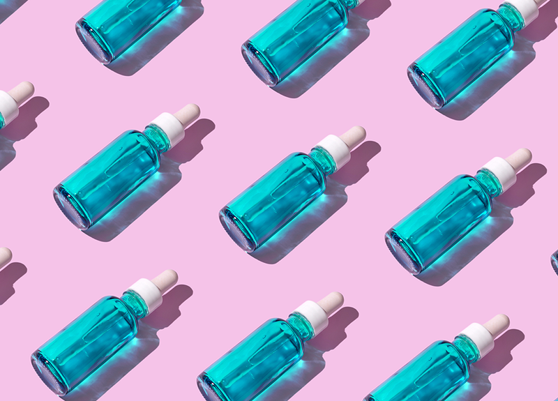 blue serum bottles on light purple background