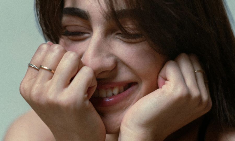 woman smiling with hands on her face