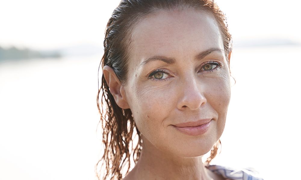 Portrait of mature woman with wet hair at a lake