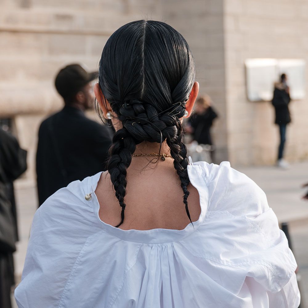Back view of woman with a twisted ponytails hairstyle and wearing a white shirt