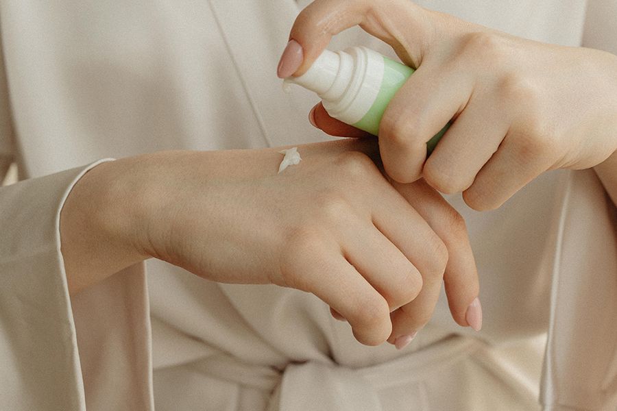 woman applying cream on hand