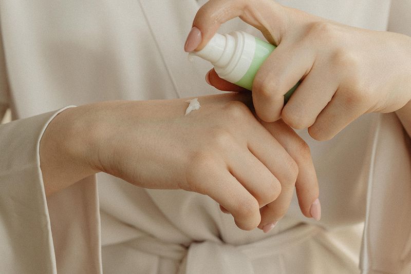 woman applying cream on hand