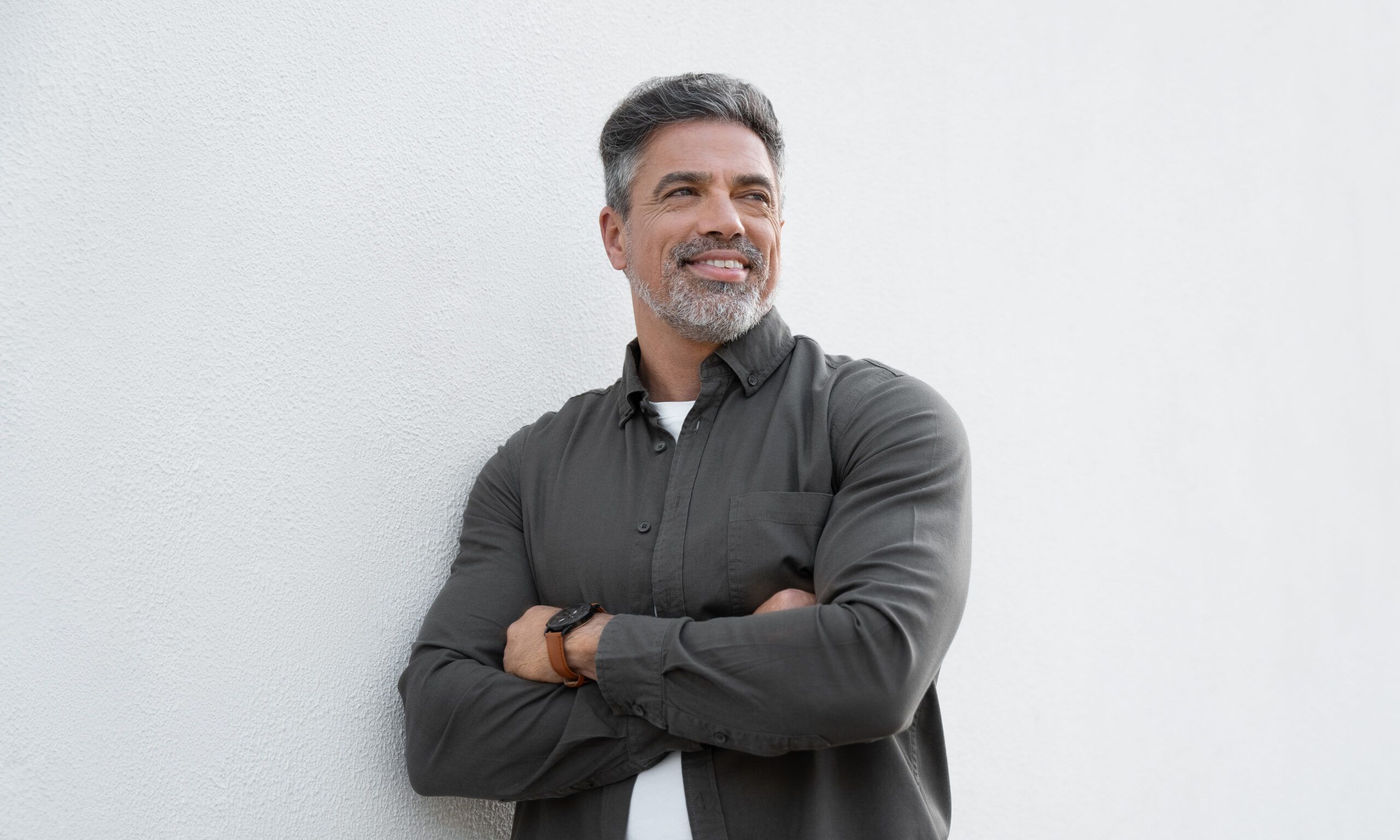 Smiling mature man standing crossed arms isolated on white background