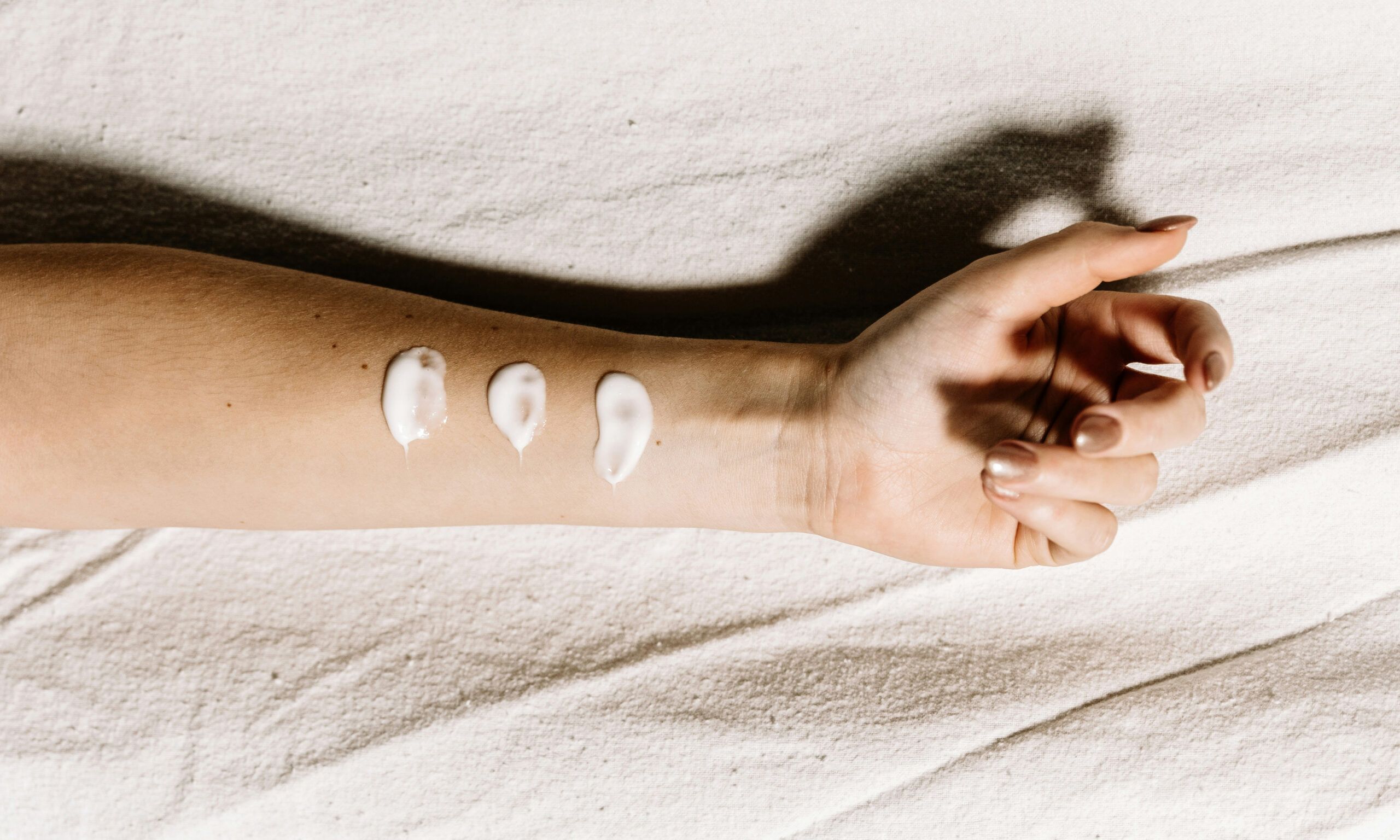 arm with three skin care smears on it