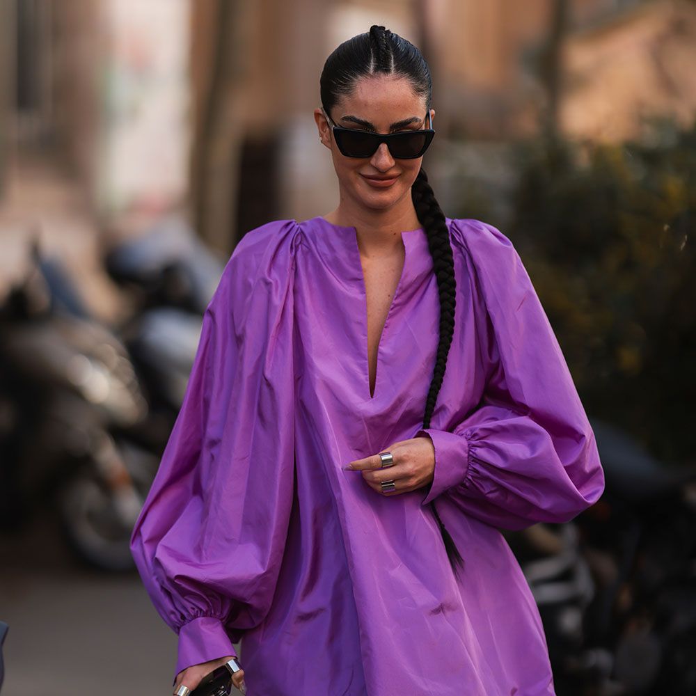 Woman in purple long-sleeved mini dress with a faux-hawk braided ponytail